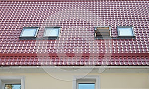 Red Metal tiled Roof with New Dormers, Roof Windows, Skylights, Rain Gutter System and Roof Protection from Snow Board