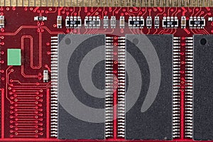 Red microcircuit of old computer random access memory with black microcircuits, top view