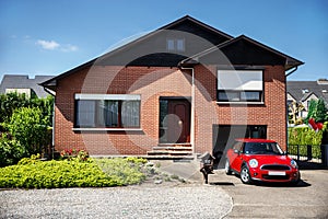 Red Mini Cooper and a beautiful house photo