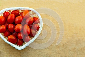 Red mini tomato vegetables many fruits in a basket heart shape copy space culinary design