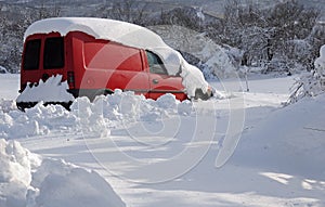 Red minivan in deep snow