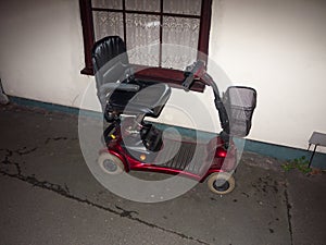 red mobility scooter parked outside in front of house disability