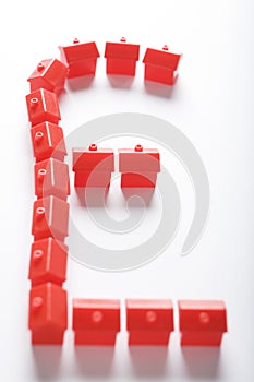 Red model houses in shape of sterling symbol photo