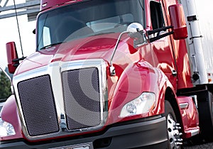 Red modern big rig semi truck with shiny grille and painted surf photo