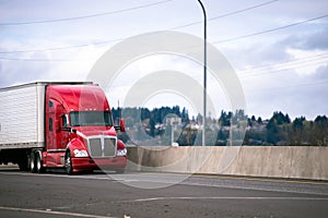 Red modern big rig semi truck tractor transporting commercial go