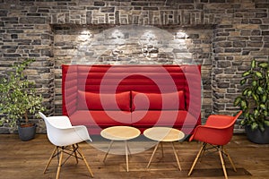 red modern couch chairs and tables illuminated with spotlights in front