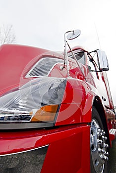 Red modern semi truck close view on light background