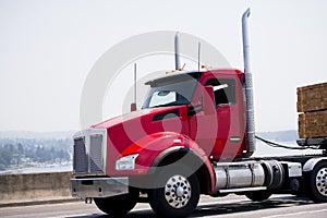 Red modern semi truck with day cab and flat bed trailer carry lu