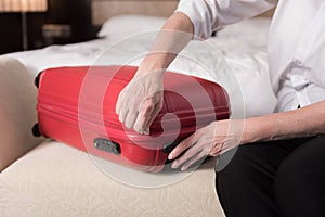 Red modern valise lying on the sofa