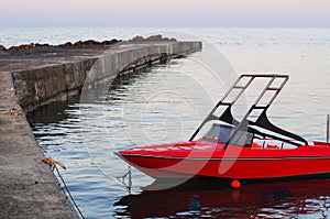Red motor boat moored at the pier