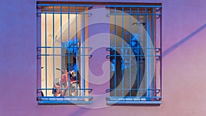 Red motorcycle behind blue bars on a purple building