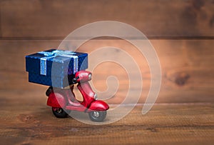 Red motorcycle vespa are Transporting Blue gift box