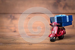 Red motorcycle vespa are Transporting Blue gift box on old and v