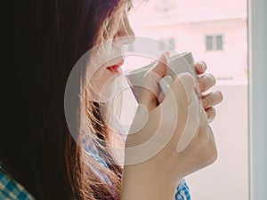 Red mouth of asian girl in blue pajamas and hold hot coffee for