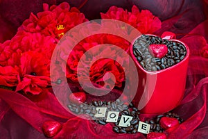 Red mug rosted coffee beans with heart chocolates red flowers Love letter