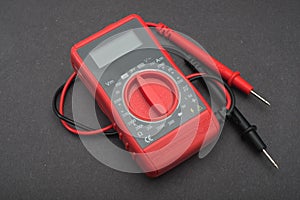 Red multimeter on a black background