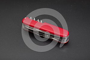 Red multitool knife on black background