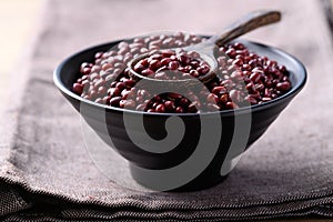 Red mung bean or Azuki bean in black bowl with spoon