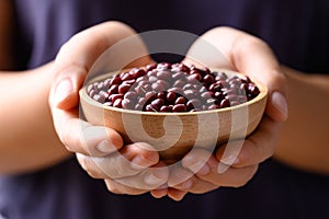 Red mung bean or Azuki bean in wooden bowl holding by hand