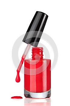 Red nail polish bottle with drop on white