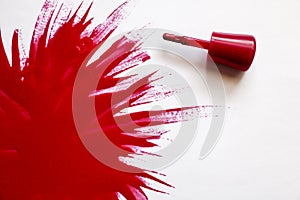 Red nail polish. explosion of color. Brush with red nail polish with large spot of varnish on a white background.