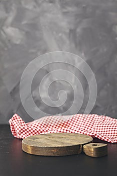 Red napkin at empty cutting board on gray background. Copy space
