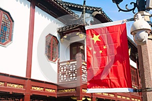 Red national flag of China against old chinese buildings at Yuyuan Garden in Shanghai, China