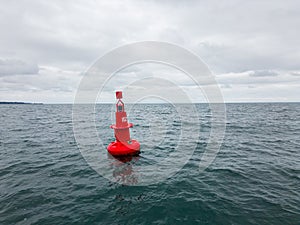 Red Navigational buoy in sea with clouds slow motion