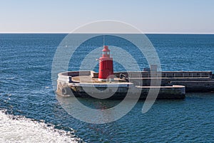 Red navigational light on a breakwater at a port