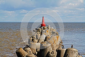 Red navigational signal buoy on breakwaters