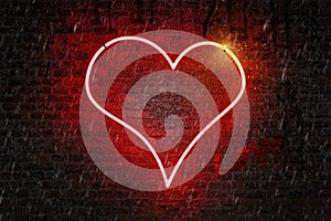 Red neon heart shaped sign on a wet brick wall