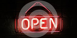 Red neon open sign glowing brightly on dark textured background for business promotions photo