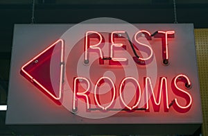 Red neon RESTROOMS sign