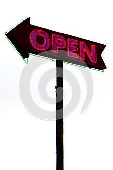Red neon sign on rusty metal arrow on white background