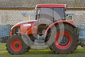 Red new wheeled tractor of medium size. Bashkortostan, Russia - 12 June, 2021.