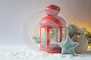 A red New Year`s candlestick and other decorations are on a snow-covered light background.