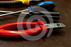 Red nippers pruning cable crimping power strip screwdriver closeup background industrial equipment