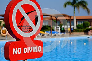 Red no diving warning sign at the poolside