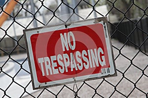 Red No Trespassing Sign On Fence