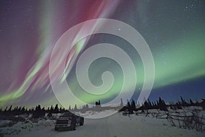 Red northern lights and watching man with his truck.
