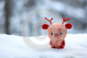 a red-nose reindeer toy on a snowy surface