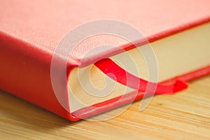 Red notebook close-up on the wooden table. Stylish sketchbook for painting, drawing and writing.