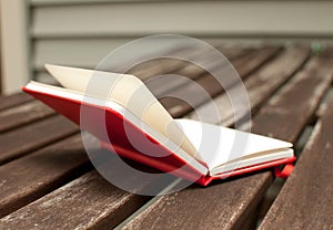 Red notebook open on wooden table