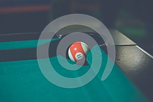 Red, number 11, billiard ball in a pool table. Vintage style noise effect