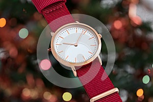 Red nylon strap wrist watch in front of Christmas lights