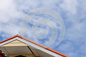 Red oak and brown Gable roof isolate on blue sky with clouds