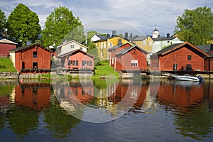 Red old barns on the river bank on a sunny summer day. Old Porvoo, Finland