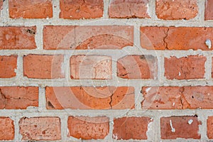 Red old faded bricks wall background with cracks and flaws