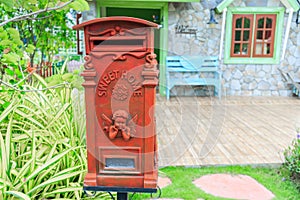 Red old-fashioned mailbox or vintage post box in front of House.