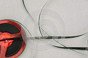 Red old film reel on a green background. 16mm film reel. Filmstrip top view. Flat lay